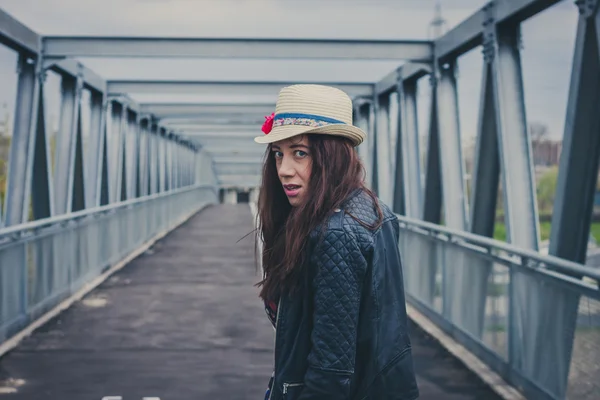Pretty girl walking away on a bridge — Stock Photo, Image