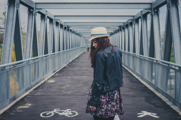 Pretty girl walking away on a bridge — Stock Photo, Image