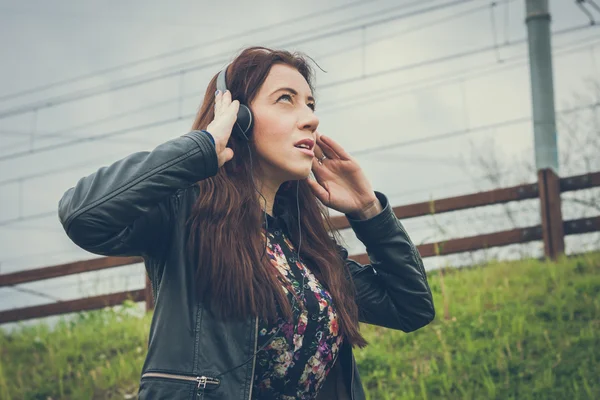 Pretty girl with long hair listening to music — Stock Photo, Image