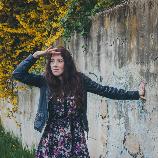 Chica bonita con el pelo largo apoyado contra una pared de hormigón —  Fotos de Stock