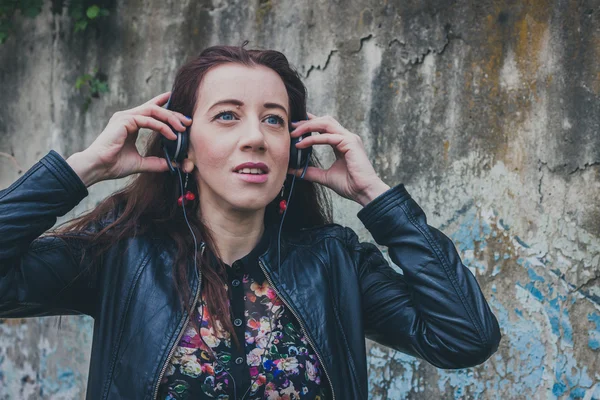 Pretty girl with long hair listening to music — Stock Photo, Image