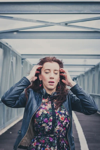 Jolie fille aux cheveux longs posant sur un pont — Photo