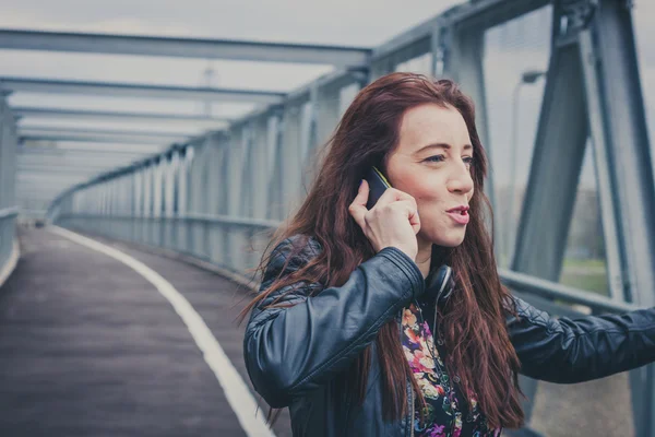 Красивая девушка с длинными волосами разговаривает по телефону — стоковое фото