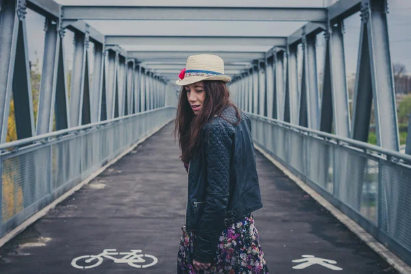 Pretty girl walking away on a bridge — Stock Photo, Image