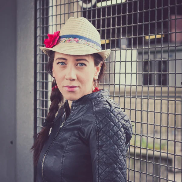 Chica bonita con sombrero y chaqueta de cuero posando — Foto de Stock