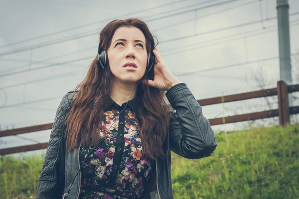 Pretty girl with long hair listening to music — Stock Photo, Image