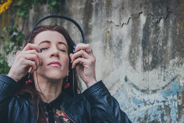 Söt flicka med långt hår som lyssnar på musik — Stockfoto