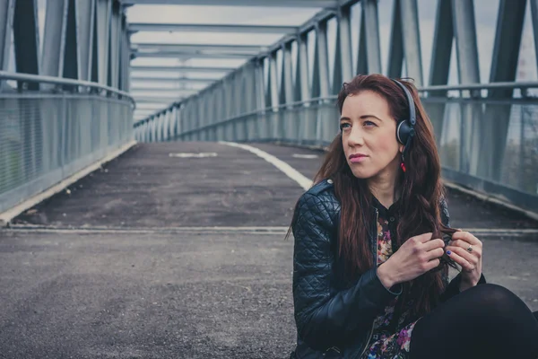 Pretty girl sitting in the middle of the street — Stock Photo, Image