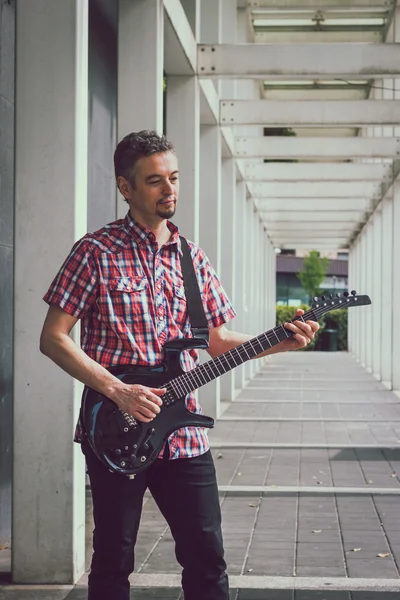Man in short sleeve shirt playing electric guitar — Stock fotografie