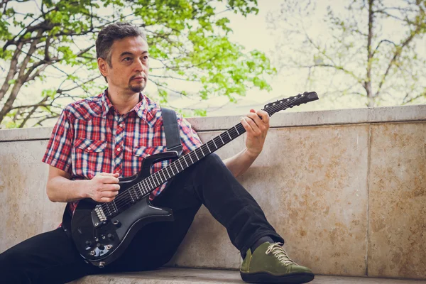 Homem de manga curta camisa tocando guitarra elétrica — Fotografia de Stock