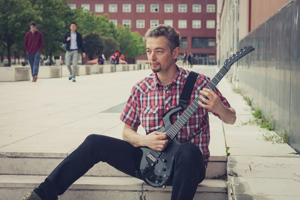 Man in short sleeve shirt playing electric guitar — Stock Photo, Image