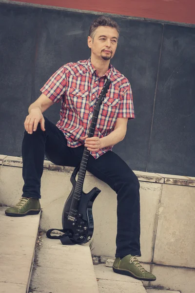 Man in short sleeve shirt playing electric guitar — Stock Photo, Image