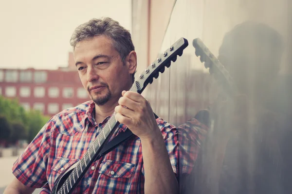 Man in short sleeve shirt playing electric guitar — Stock Photo, Image