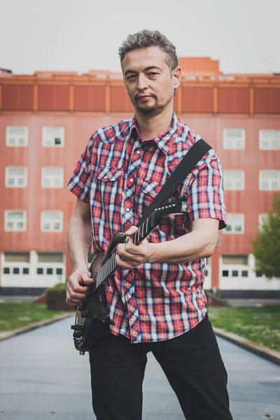 Man in short sleeve shirt playing electric guitar — Stock Photo, Image