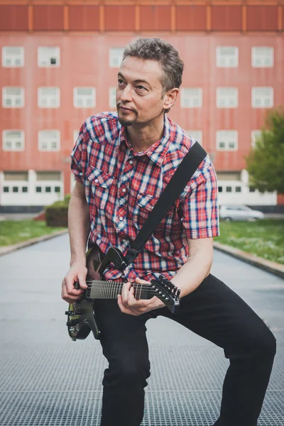 Man in short sleeve shirt playing electric guitar — Stock Photo, Image