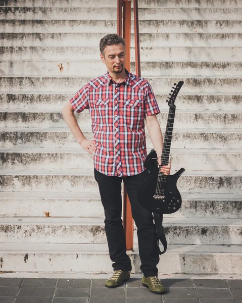 Man in short sleeve shirt playing electric guitar — Stock fotografie