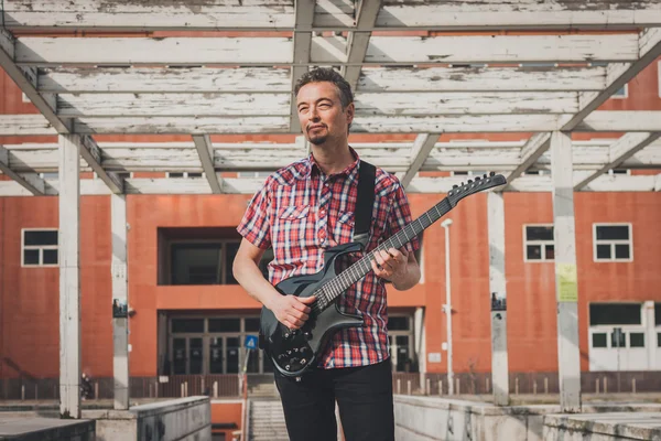 Man in short sleeve shirt playing electric guitar — Stock Photo, Image