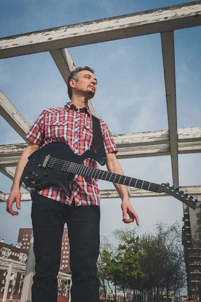 Man in short sleeve shirt playing electric guitar — Stock Photo, Image