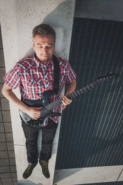 Man in short sleeve shirt playing electric guitar — Stock fotografie