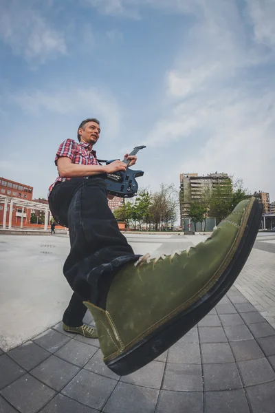 Man in short sleeve shirt playing electric guitar — Stock fotografie