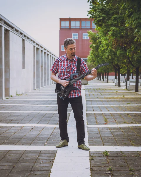 Man in short sleeve shirt playing electric guitar — Stock Photo, Image