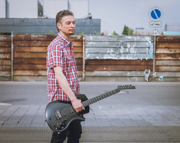 Hombre en camisa de manga corta sosteniendo la guitarra eléctrica — Foto de Stock