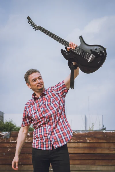 Άνθρωπος σε κοντό μανίκι πουκάμισο κρατώντας ηλεκτρική κιθάρα — Φωτογραφία Αρχείου