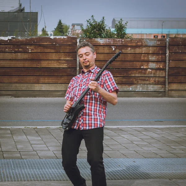 Hombre en camisa de manga corta tocando la guitarra eléctrica — Foto de Stock