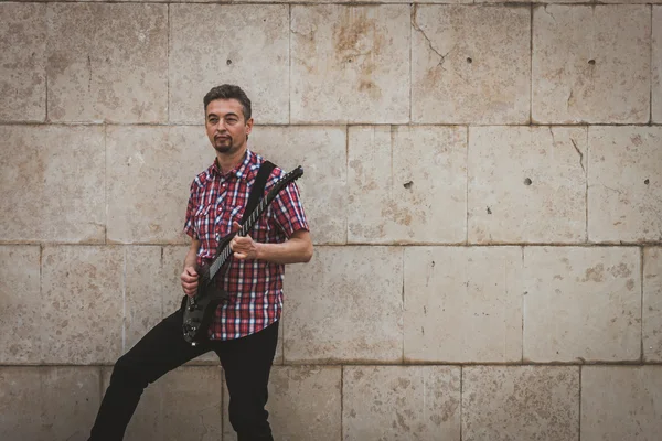 Man in short sleeve shirt playing electric guitar — 图库照片