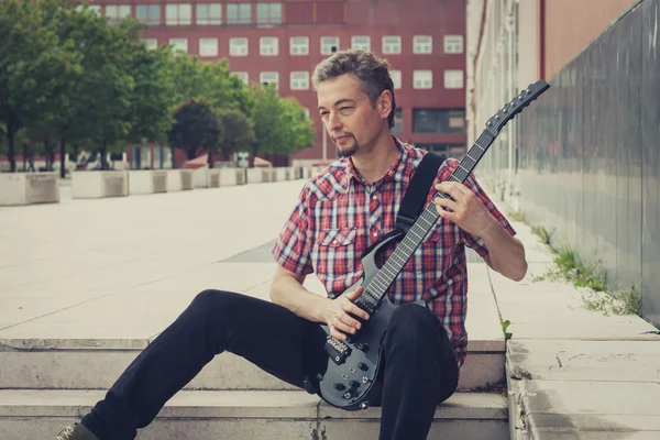 Man in short sleeve shirt playing electric guitar — Stock Photo, Image