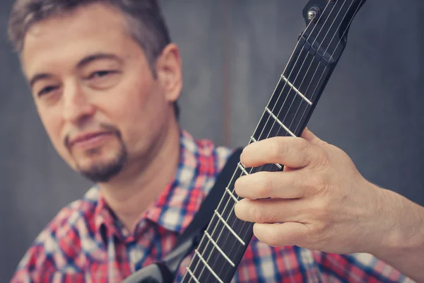 Man in short sleeve shirt playing electric guitar — Stock Photo, Image