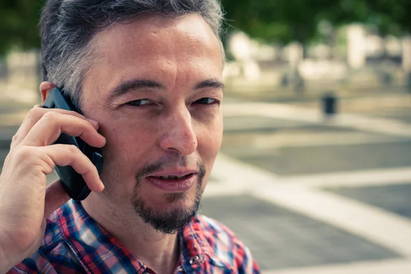 Мужчина в рубашке с коротким рукавом говорит по телефону — стоковое фото