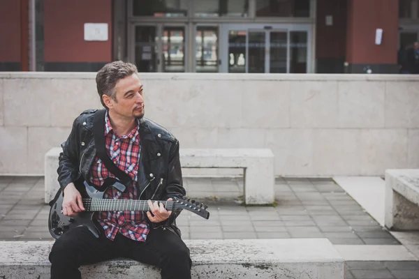 Man in black leather jacket playing electric guitar — Stock Photo, Image