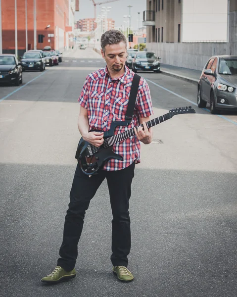 Man in short sleeve shirt playing electric guitar — Stock Photo, Image