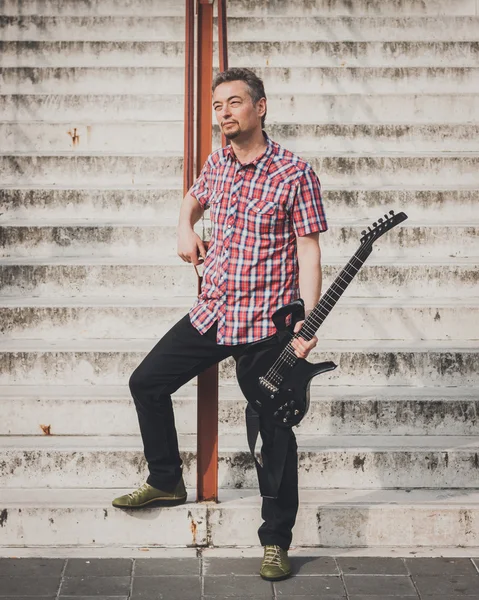 Hombre en camisa de manga corta tocando la guitarra eléctrica — Foto de Stock