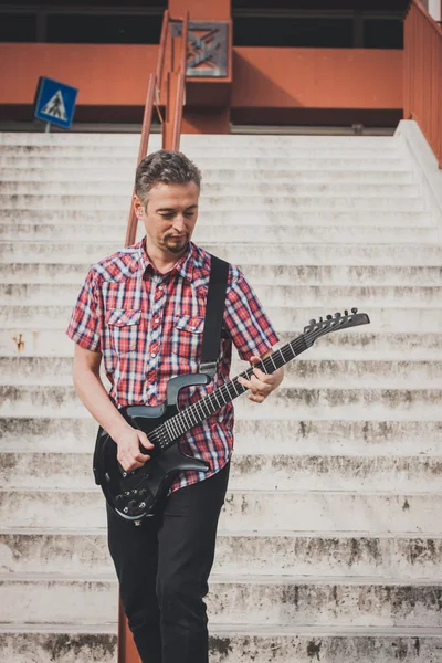 Man in short sleeve shirt playing electric guitar — Stock Photo, Image