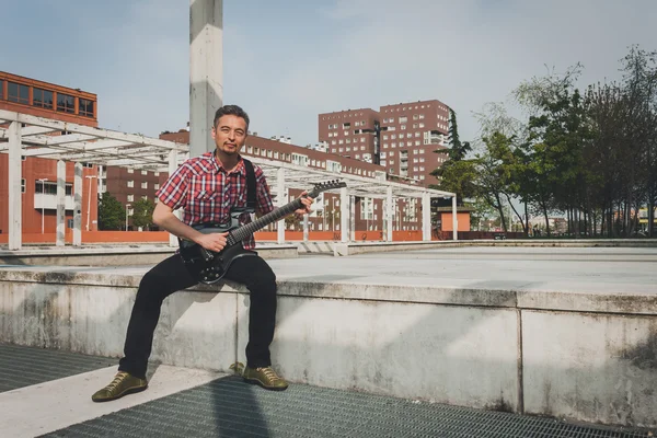 Man in short sleeve shirt playing electric guitar — Stock Photo, Image