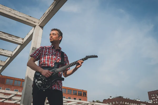 Homem de manga curta camisa tocando guitarra elétrica — Fotografia de Stock