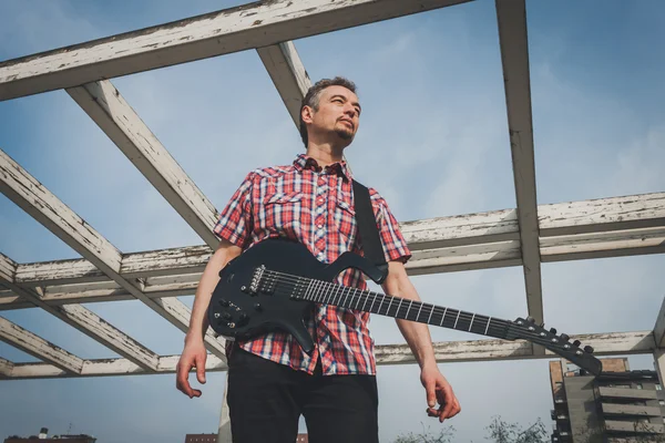 Man in short sleeve shirt playing electric guitar