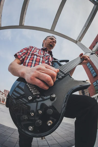 Mann im kurzärmeligen Hemd spielt E-Gitarre — Stockfoto