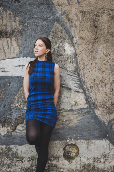 Jolie fille posant contre un mur de béton — Photo