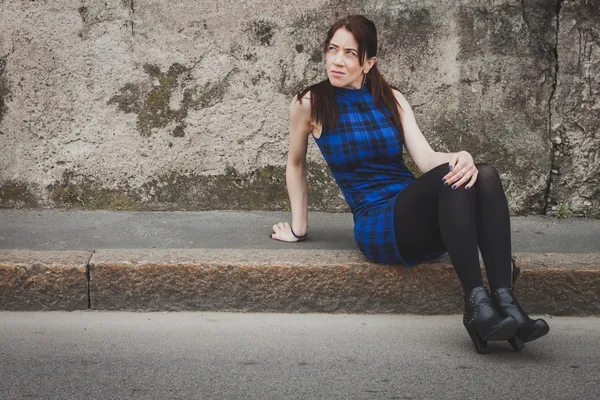 Pretty girl sitting on sidewalk — Stock Photo, Image