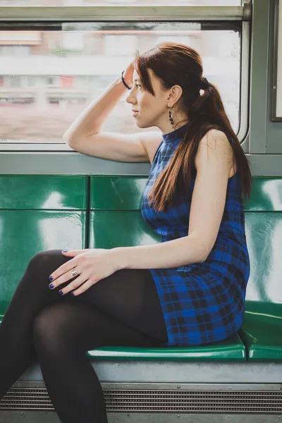 Linda chica sentada dentro del tren subterráneo — Foto de Stock