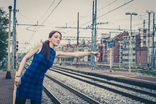 Pretty girl hitchhiking along the tracks — Stock Photo, Image