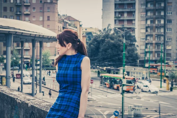 Bella ragazza seduta su un muro di cemento — Foto Stock