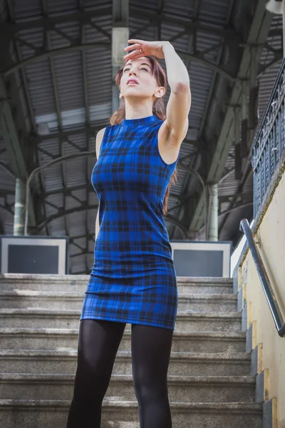 Pretty girl posing in railroad station underpass — Stock Photo, Image