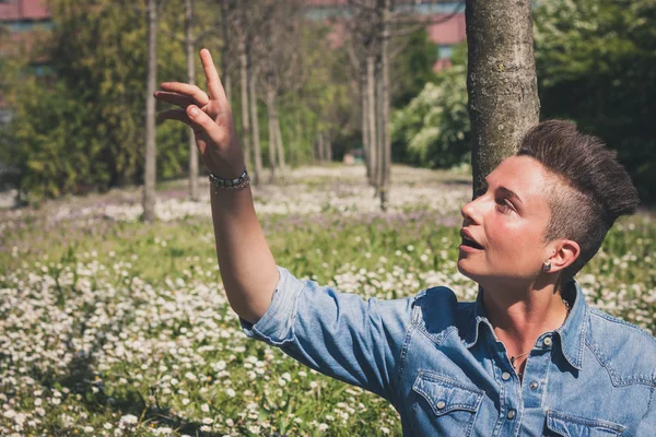 Fille aux cheveux courts assis dans l'herbe — Photo