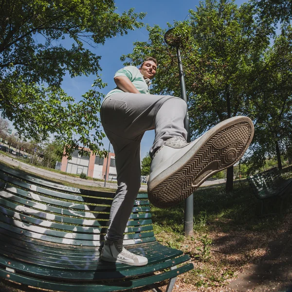 Fisheye shot of short hair girl standing on a bench — Stock Photo, Image