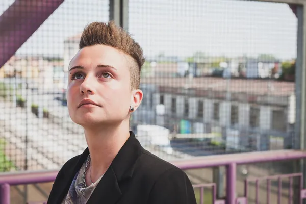 Jolie fille aux cheveux courts posant sur un pont — Photo