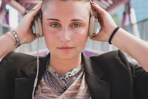 Pretty short hair girl listening to music on a bridge — Stock Photo, Image